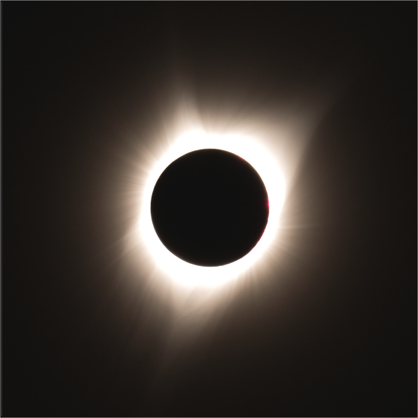 A total solar eclipse captured in 2017 in eastern Oregon, showing the darkened moon perfectly centered with the sun’s glowing corona radiating outward.