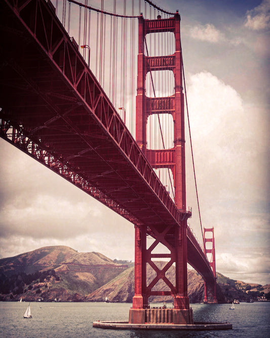 Vintage-style photo of the Golden Gate Bridge viewed from Fort Point, with added texture and vignetting for a nostalgic, early color photography effect.
