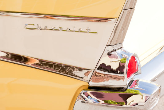 Close-up of a vintage yellow and cream Chevrolet fin with chrome trim and red taillight, photographed during Petaluma’s American Graffiti event.