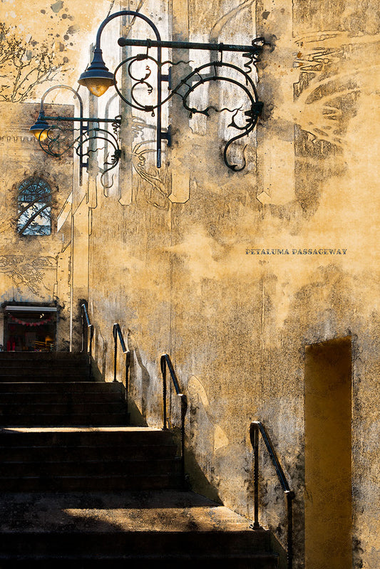 A digitally altered image of a historic stairway in downtown Petaluma, California, featuring ornate wrought iron lamps and weathered textures—part of the “Petaluma Landmarks” series and stylized to resemble a vintage painting.